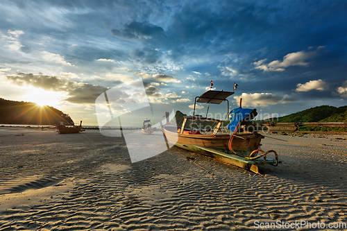 Image of Long tail boat on beach on sunset