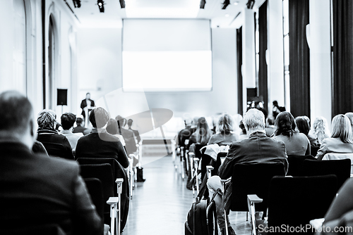 Image of Speaker giving a talk in conference hall at business event. Rear view of unrecognizable people in audience at conference hall. Business and entrepreneurship concept. Black and white selenium image