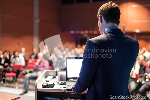 Image of Public speaker giving talk at business event.