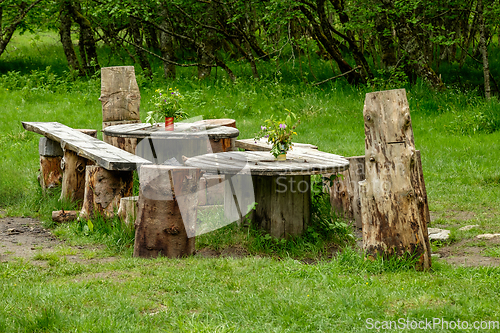 Image of picnic area made of old wood in the forest decorated with flower