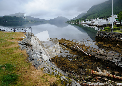 Image of boat slip in the center of a small town with a reflection of the