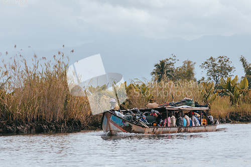 Image of overloaded boat taxi in countryside on river