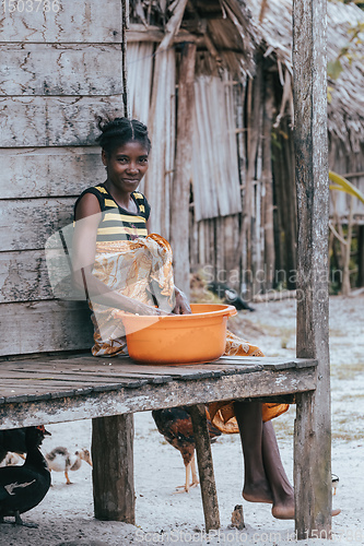 Image of Malagasy woman washes dishes, Madagascar countryside