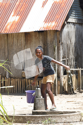 Image of Malagasy girl goes for water to a public pump, Madagascar