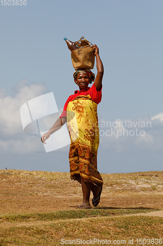 Image of Malagasy woman carry heavy loads on head. Madagascar