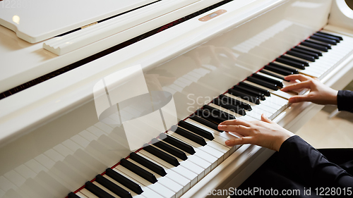 Image of Womans hands on the keyboard of the piano closeup