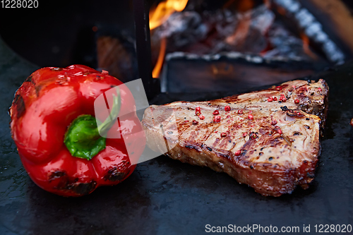 Image of Grilled T-Bone Steak on serving board on wooden background