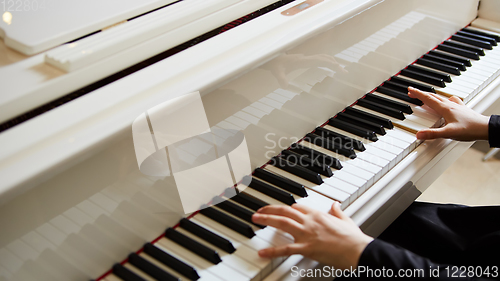 Image of Womans hands on the keyboard of the piano closeup