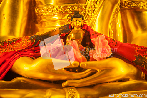 Image of Small Buddha Sakyamuni statue in hands of large
