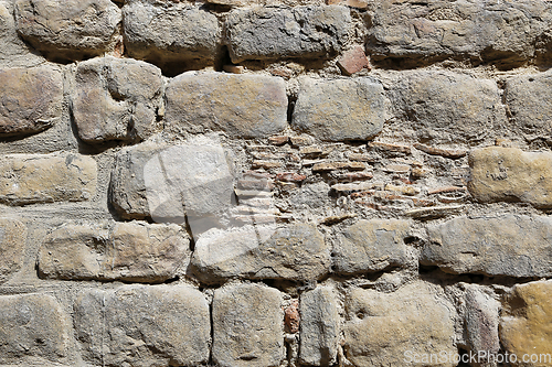 Image of Very old vintage wall from large stones of various shapes and br