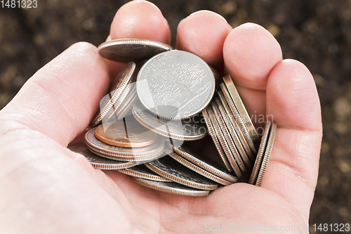 Image of the hand of a man with coins