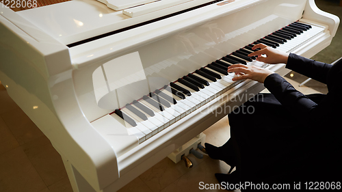 Image of Womans hands on the keyboard of the piano closeup