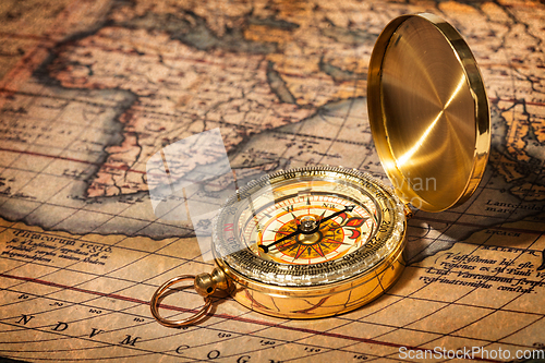Image of Old vintage golden compass on ancient map