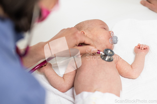 Image of Baby lying on his back as his doctor examines him during a standard medical checkup