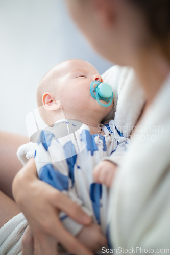 Image of Young mother is holding her little baby boy.