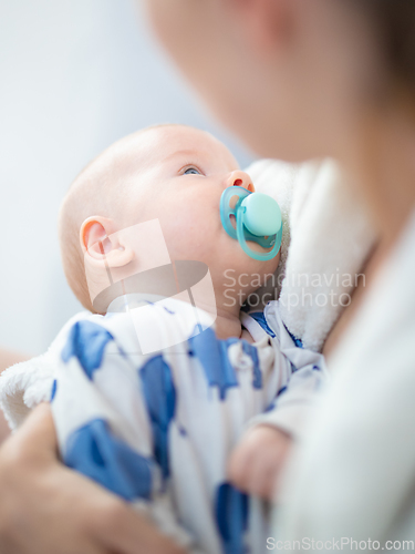 Image of Young mother is holding her little baby boy.