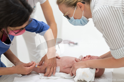 Image of Baby beeing vaccinated by pediatrician in presence of his mother. Preventive vaccination against Diphtheria, whooping cough, tetanus, hepatitis, haemophilus influenzae, pneumococcus, poliomyelitis