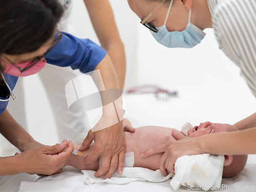 Image of Baby beeing vaccinated by pediatrician in presence of his mother. Preventive vaccination against Diphtheria, whooping cough, tetanus, hepatitis, haemophilus influenzae, pneumococcus, poliomyelitis