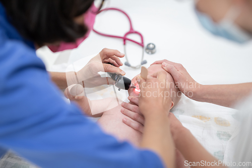 Image of Baby lying on his back as his doctor examines him during a standard medical checkup