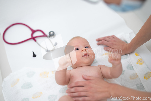 Image of Baby lying on his back as his doctor examines him during a standard medical checkup