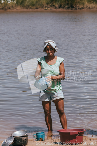 Image of Malagasy woman washes dishes, Madagascar countryside