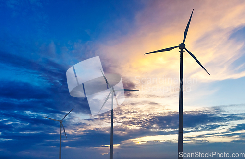 Image of Wind generator turbines sihouettes on sunset