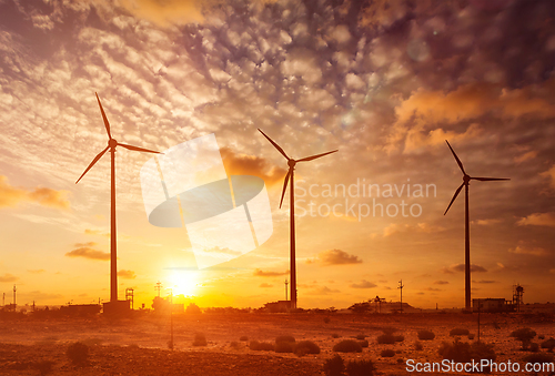 Image of Wind generator turbines sihouettes on sunset