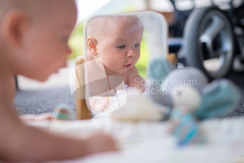 Image of Beautiful shot of mirror reflectiona of cute baby boy playing with toys.