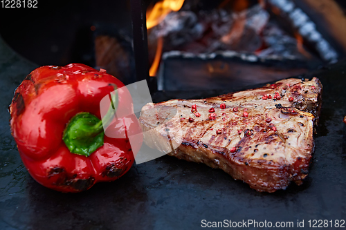 Image of Grilled T-Bone Steak on serving board on wooden background