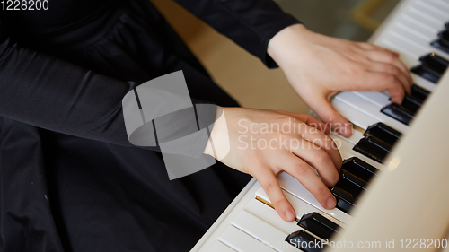 Image of Womans hands on the keyboard of the piano closeup