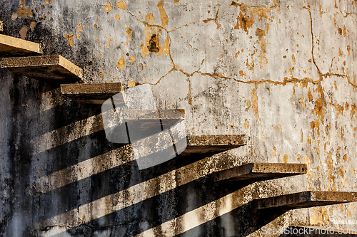 Image of Stairs casting shadow on old weathered wall