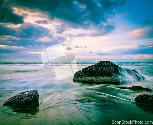 Image of Waves and rocks on beach of sunset