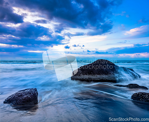 Image of Waves and rocks on beach of sunset