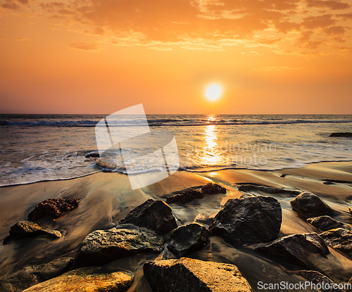 Image of Waves and rocks on beach of sunset