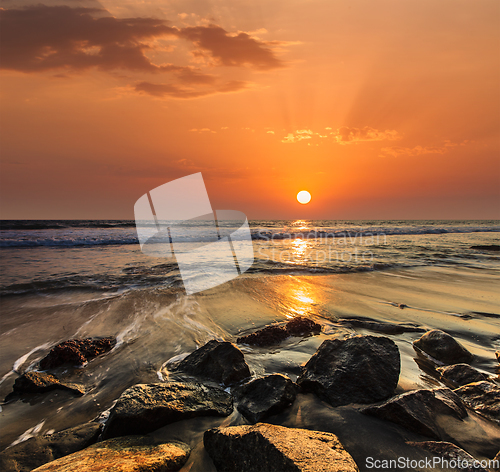 Image of Waves and rocks on beach of sunset