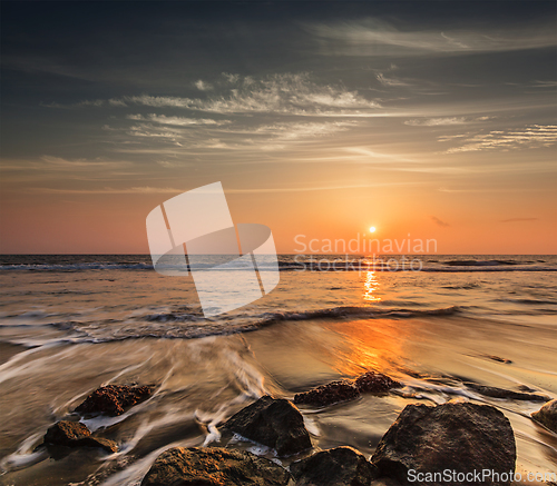 Image of Waves and rocks on beach of sunset