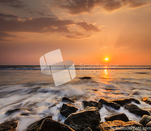 Image of Waves and rocks on beach of sunset