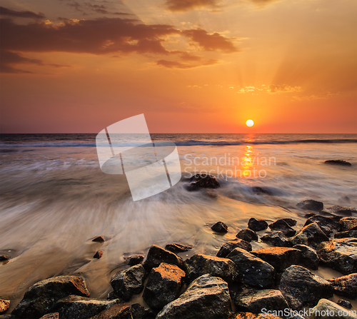 Image of Waves and rocks on beach of sunset