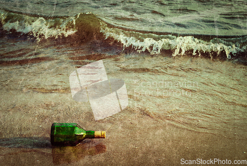 Image of Message bottle on beach in waves