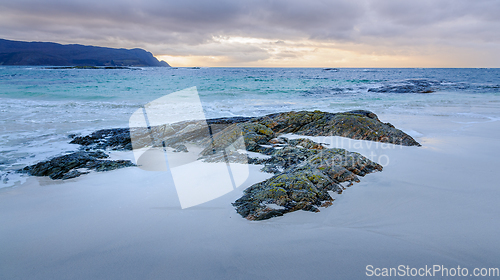 Image of rock formations coming up through the sand on the beach