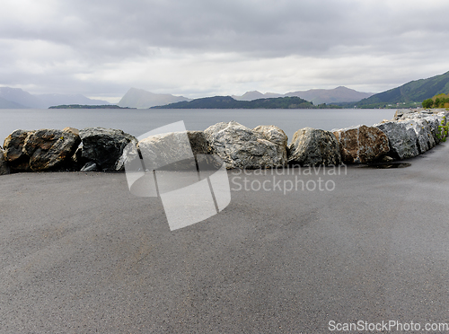 Image of stone fence on quay with mountains