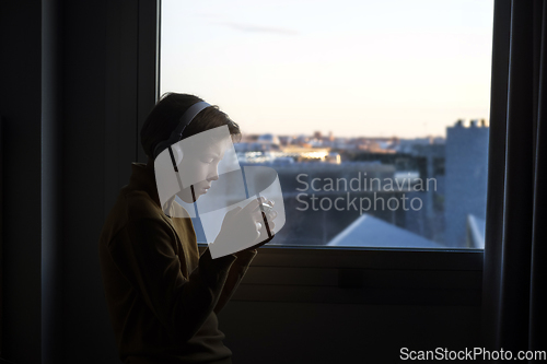 Image of Teenager playing near the window