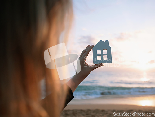 Image of Wooden figurine of house in female hands