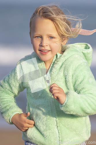 Image of A 5-year-old girl in a green jacket is running