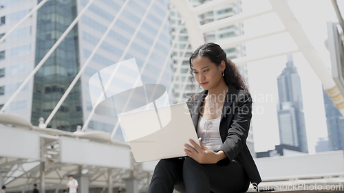Image of Portrait of young asian businesswoman working on laptop