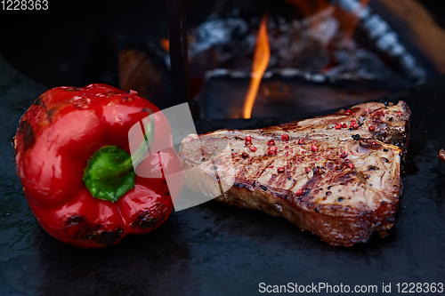 Image of Grilled T-Bone Steak on serving board on wooden background