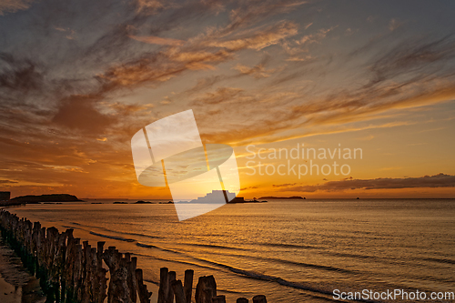 Image of Golden sea sunset on the background of vintage wooden breakwaters