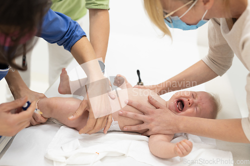 Image of Baby beeing vaccinated by pediatrician in presence of his mother. Preventive vaccination against Diphtheria, whooping cough, tetanus, hepatitis, haemophilus influenzae, pneumococcus, poliomyelitis