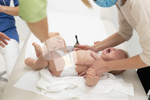 Image of Baby beeing vaccinated by pediatrician in presence of his mother. Preventive vaccination against Diphtheria, whooping cough, tetanus, hepatitis, haemophilus influenzae, pneumococcus, poliomyelitis