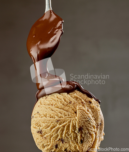 Image of melted chocolate sauce flowing on ice cream